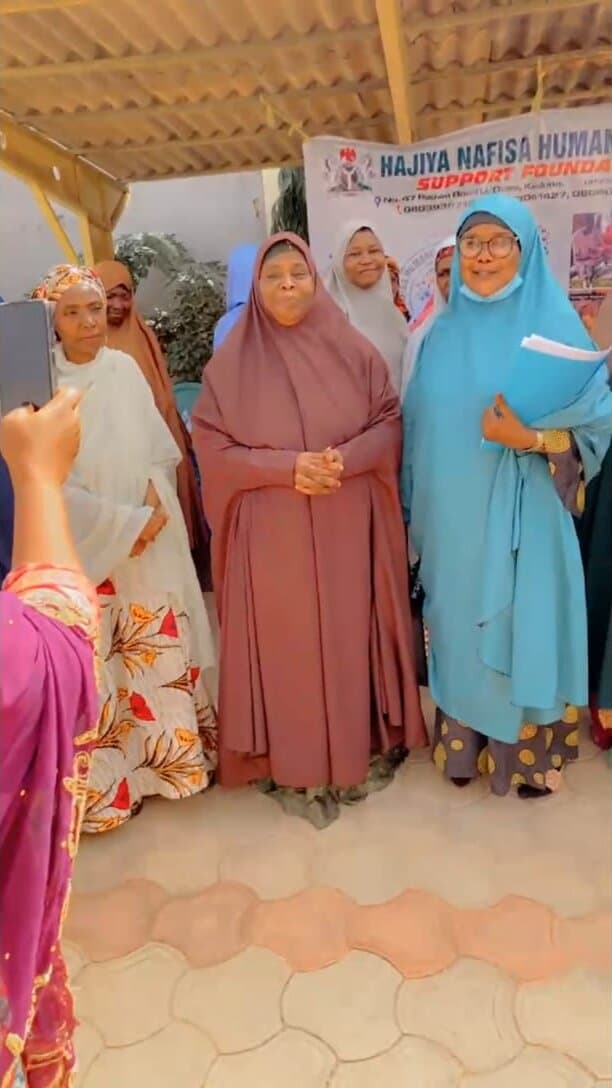 Women gathered at a Hajiya Nafisa Foundation community event in front of the foundation banner